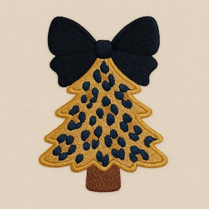 Op de afbeelding: Geborduurde kerstboom met een zwarte strik bovenaan. De boom heeft een gouden omtrek, een luipaardprint in goud en marineblauw en een bruine stam. Het ontwerp staat op een crèmekleurige achtergrond.