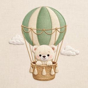 Puede incluir: Imagen bordada de un oso de peluche en un globo aerostático. El globo es verde y crema con una cesta tejida. El oso tiene una expresión dulce y está rodeado de dos nubes blancas. La imagen está sobre un fondo color crema.