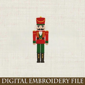 May include: Embroidered image of a toy soldier nutcracker in red, green, and gold. The nutcracker has a black mustache and is wearing a red hat. The text "DIGITAL EMBROIDERY FILE" is at the bottom of the image.