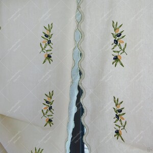 May include: Off-white fabric with embroidered olive branches featuring green leaves and black and yellow olives. A light blue scalloped trim with a gold border runs vertically down the center. The fabric has a subtle diamond pattern.