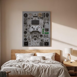 May include: A gray wall art piece featuring a disassembled Xbox controller and various electronic components. The artwork includes a white controller, circuit boards, and other small parts arranged on a gray background.