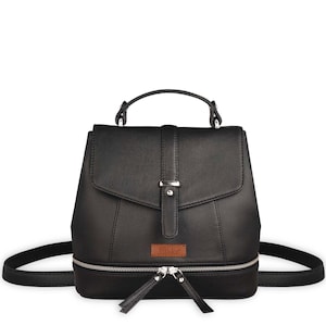 Peut inclure: Un sac à dos noir avec une poignée supérieure et un rabat fermé par une sangle verticale dotée d'une boucle argentée. Le sac présente un compartiment inférieur zippé avec deux tirettes argentées et une étiquette rectangulaire Sthko.