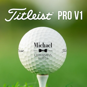 Golf ball on tee with Wedding Bowtie design. Brand and type of golf ball is Titleist Pro V1.
