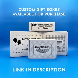 A collection of custom gift boxes for golf balls with various designs and messages, including a "Happy Father's Day" box, a "Happy 1st Father's Day" box, a "Congratulations on Your Retirement" box and a "Happy Birthday" gift box. These boxes are available for purchase and there is a link provided in the description.