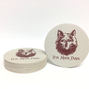 Custom design coasters featuring red Fox Mask Farm logo design. Coasters are shown against a white background.