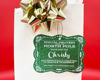 May include: A green glitter gift tag with white text that reads "Special Delivery from the North Pole Made Just For Christy Authentically Crafted in Santa's Workshop Delivery via Reindeer Mail".