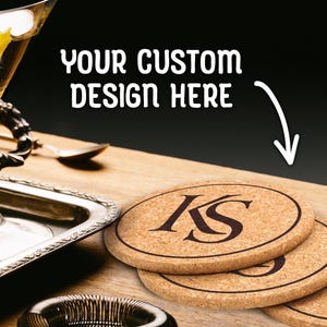 Custom design cork coasters are shown on a wooden table next to a metal tray. The tray has a martini glass on it.