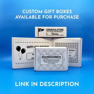 A collection of custom gift boxes for golf balls with various designs and messages, including a "Happy Father's Day" box, a "Happy 1st Father's Day" box, a "Congratulations on Your Retirement" box and a "Happy Birthday" gift box. These boxes are available for purchase and there is a link provided in the description.