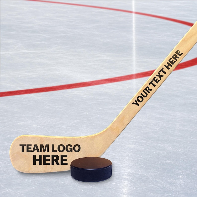 A hockey stick with a logo on it, placed on an ice rink with a puck resting on the ice.