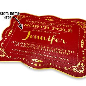 A gold foil cardstock Santa gift tag is shown on a white surface. The text above it reads, Custom Name Here.