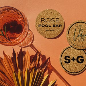 Three coasters with various designs sit next to drink on orange background.