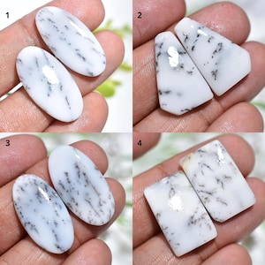 Puede incluir: Cuatro conjuntos de piedras preciosas de ópalo dendrítico blanco. Cada conjunto presenta dos piedras con formas únicas: ovaladas, trapezoidales y rectangulares. Las piedras tienen inclusiones negras en forma de árbol.