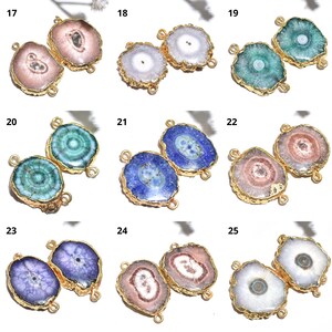 Könnte beinhalten: Eine Sammlung von Edelsteinanhängern in verschiedenen Farben, darunter Rosa, Blau, Grün und Weiß. Jeder Anhänger hat einen goldfarbenen Metallrand und zwei Schlaufen zum Befestigen an einer Kette oder einem anderen Schmuckbestandteil.
