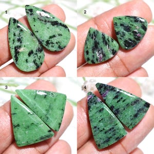 Può includere: Quattro paia di pietre preziose di zoisite verde con inclusioni nere e rosa. Le pietre sono tagliate in varie forme, tra cui a goccia, triangolari e trapezoidali. Le pietre sono esposte su uno sfondo neutro.