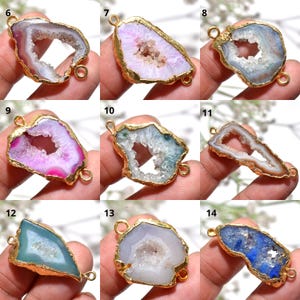 May include: A selection of gold-plated gemstone pendants in shades of pink, blue, and green. Each pendant showcases a distinctive geode design with a crystalline interior. The pendants are irregularly shaped and have small loops for attaching to jewellery.