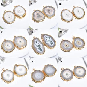 May include: Nine pairs of agate gemstone pendants. Each pendant has a polished, irregular shape, with a gold-coloured metal edge and a small loop. The agate slices display shades of white, grey, and cream.