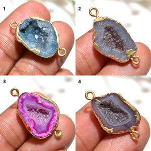 May include: Four gemstone pendants with gold-coloured metal edging and loops. The pendants feature different coloured crystal formations: light blue, lavender, bright pink, and a darker purple. Suitable for jewellery making.