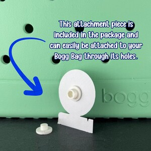 Peut inclure: Pi&egrave;ce de fixation blanche pour un sac Bogg, avec un design circulaire et un petit poteau cylindrique. L'image comprend le texte : "Cette pi&egrave;ce jointe est incluse dans l'emballage et peut facilement &ecirc;tre fix&eacute;e &agrave; votre sac Bogg &agrave; travers ses trous."
