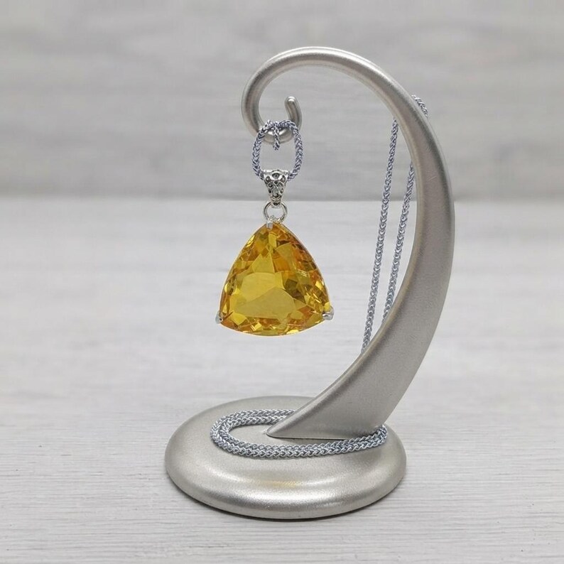 Trillion cut yellow sapphire pendant necklace front view in box, bright sunshine gemstone with faceted faces and minimal prongs, bold statement jewellery for women with sleek chain, luxury gift idea; natural internal features and reflections may be visible in closeups.