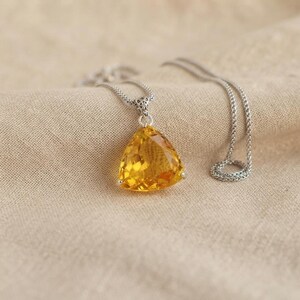 Sunshine yellow sapphire trillion cut pendant necklace in presentation box, faceted triangle gemstone with 3 prong mount and smooth chain, bold women’s statement jewellery for parties and weddings; color and reflections may vary by lighting and screen settings.