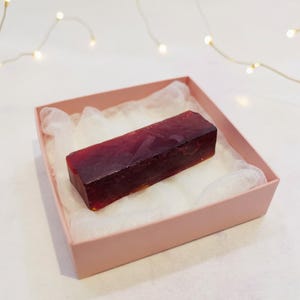 Può includere: Una tazza di ceramica bianca con manico nero e la scritta "But First, Coffee" in nero, con un carattere a mano. La tazza è su una superficie bianca.