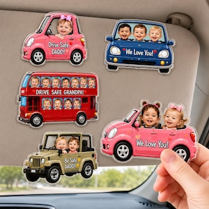 May include: Five acrylic vehicle-shaped ornaments featuring custom photo cutouts of children. Designs include a pink car with 'Drive Safe DADDY', a blue car with 'We Love You!', a red double-decker bus with 'DRIVE SAFE GRANDPA!', a tan jeep with 'Be Safe DADDY', and a pink convertible with 'We Love You!'.
