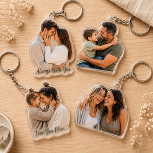 May include: Four clear acrylic keychains featuring custom photo prints of people. One keychain shows a couple with the text Always With You, another a parent and child, one a child and mother with Love You Mom, and one two smiling adults.