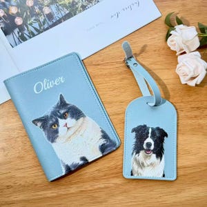 以下が含まれることがあります： グレーと白の猫の画像と白い文字でOliverと印刷された水色のパスポートホルダーと、白黒の犬の画像が印刷されたお揃いの水色のラゲッジタグのセット。