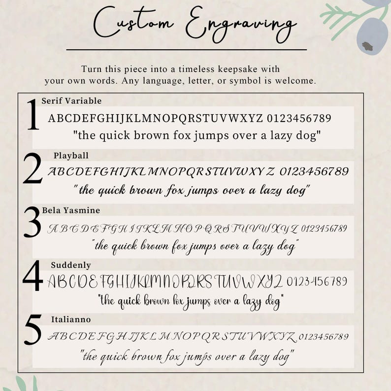 May include: A custom engraving font selection chart featuring five distinct typeface options labeled Serif Variable, Playball, Bela Yasmine, Suddenly, and Italianno. Each option displays the full alphabet, numbers zero through nine, and a sample sentence.