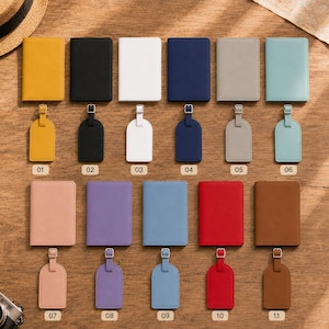 May include: A collection of eleven passport holders and matching luggage tags in various solid colors, including yellow, black, white, navy, gray, light blue, pink, purple, blue, red, and brown, each labeled with a numbered tag from 01 to 11.