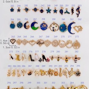 May include: A collection of assorted metal charms labeled 235 through 305, featuring various shapes like flowers, animals, celestial bodies, and shoes. Some charms include enamel colors and rhinestones. Dimensions are marked as 1.6cm by 2.0cm or 0.64in by 0.8in.