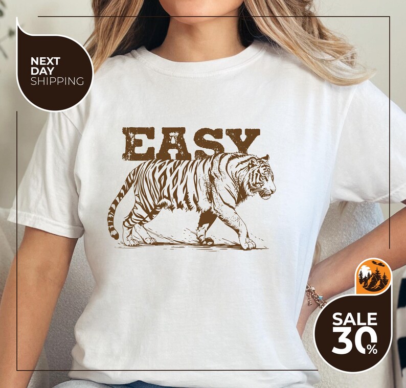 A woman wearing a white t-shirt with a graphic of a tiger and the word "EASY" printed on it.