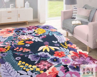 May include: A large, floral-patterned rug with a dark blue background. The rug features a variety of colorful flowers in shades of red, purple, yellow, and pink. The rug has a unique, irregular shape, adding a decorative touch to the room.