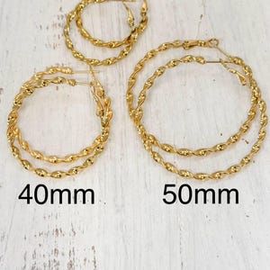 May include: Three pairs of gold-toned twisted hoop earrings in varying sizes. The pairs are labelled with text indicating diameters of 30mm, 40mm, and 50mm. Each hoop features a continuous twisted metal texture and a standard hinged post closure mechanism.