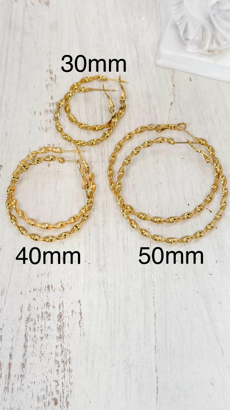 May include: Three pairs of gold-toned twisted hoop earrings in varying sizes. The pairs are labelled with text indicating diameters of 30mm, 40mm, and 50mm. Each hoop features a continuous twisted metal texture and a standard hinged post closure mechanism.