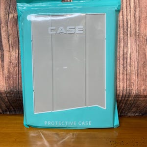 May include: A gray protective case for a tablet, packaged in a teal plastic sleeve. The word "CASE" is printed in white on the case. The words "PROTECTIVE CASE" are printed in white on the packaging.