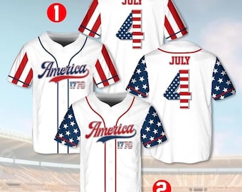 May include: White baseball jerseys with red and blue accents, featuring "America 1776" and "July 4" designs. The sleeves display red and white stripes or blue stars. The jerseys are displayed against a blurred stadium background.