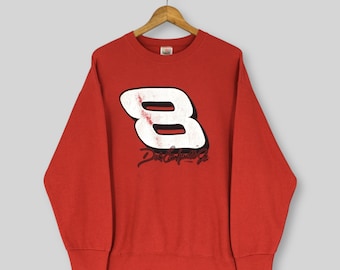 May include: A red sweatshirt with a large white number 8 on the front, featuring black accents and the text "Dale Earnhardt Jr." in a cursive font. The sweatshirt is hanging on a wooden hanger.