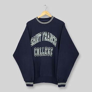 May include: Navy blue Saint Francis College sweatshirt. The sweatshirt features white lettering and trim around the collar, cuffs, and hem. The text "SAINT FRANCIS COLLEGE" is arched across the chest. The garment is hanging on a wooden hanger.