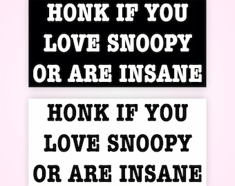 May include: Two rectangular stickers with the text "HONK IF YOU LOVE SNOOPY OR ARE INSANE." One sticker is black with white text, and the other is white with black text. The stickers are displayed on a light pink background.
