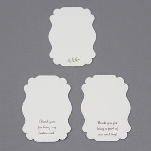 May include: Three white, blank, decorative, scalloped-edge cards with the text "Thank you for being my bridesmaid!" and "Thank you for being a part of our wedding!" printed on two of the cards.