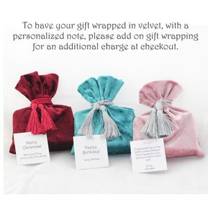 Pu&ograve; includere: Tre sacchetti regalo in velluto con frange di diversi colori ed etichette regalo personalizzate. Le etichette hanno messaggi per un compleanno, Natale e un neonato. Il testo sulle etichette recita: "Buon Natale", "Buon compleanno!" e "Congratulazioni per la nascita della piccola Haslysl. Sono cos&igrave; felice per te, e non vedo l'ora di incontrarla! Con affetto, Georgia."
