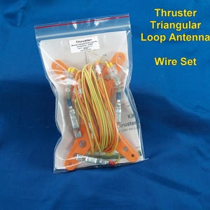 May include: A Thruster Triangular Loop Antenna Wire Set in a clear plastic bag. The kit includes orange plastic mounting brackets, yellow and green insulated wires, and metal connectors. A printed instruction sheet is visible inside the bag.