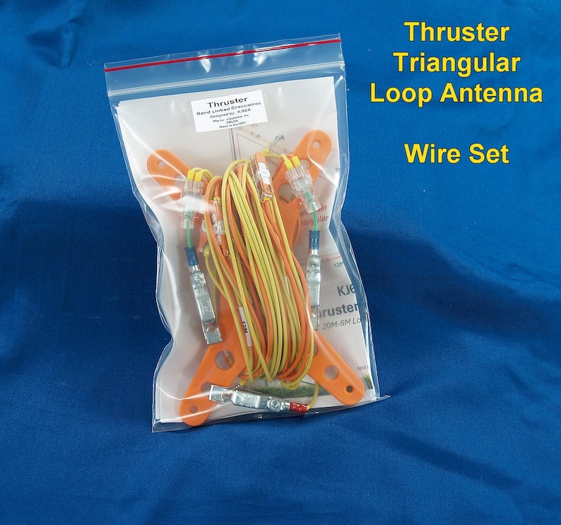 Puede incluir: Un juego de cables para antena de bucle triangular Thruster en una bolsa de pl&aacute;stico transparente. El kit incluye soportes de montaje de pl&aacute;stico naranja, cables aislados amarillos y verdes, y conectores met&aacute;licos. Se ve una hoja de instrucciones.