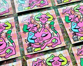 Puede incluir: Una colección de impresiones artísticas de gatos estilizados. Cada impresión presenta un gato rosa, verde y azul con un diseño de patchwork y elementos decorativos. El fondo es un patrón de cuadros rosa y blanco.