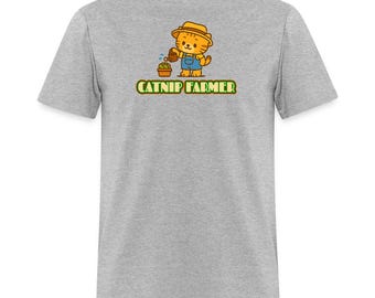 May include: A light gray t-shirt featuring a cartoon cat wearing a straw hat and overalls, watering a small plant. The text "CATNIP FARMER" is printed below the illustration in green and gold.
