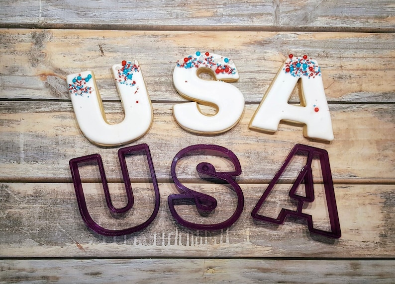 May include: USA cookie cutters and decorated cookies with red, white, and blue sprinkles.
