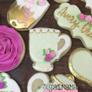 May include: A set of decorated sugar cookies with a tea party theme. The cookies are decorated with green, pink, and gold icing. The cookies feature a teacup, teapot, and a tag that says "Sweet Tea".