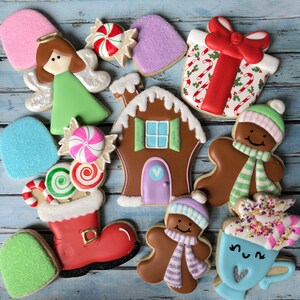 Puede incluir: Surtido de galletas de az&uacute;car con tem&aacute;tica navide&ntilde;a decoradas con glaseado y chispas. Las galletas incluyen una casa de jengibre, un mu&ntilde;eco de nieve, una media, un bast&oacute;n de caramelo, un regalo, una estrella y un &aacute;ngel.