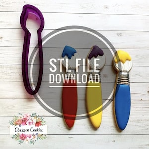 Può includere: Tre biscotti a forma di pennello decorati con glassa blu, viola e gialla. È anche visibile uno stampino per biscotti in plastica viola a forma di pennello. Il testo "STL FILE DOWNLOAD" è visibile nell'immagine.